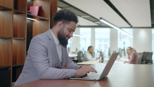 Un homme d'affaires afro-américain travaille dur dans un bureau moderne pour réussir