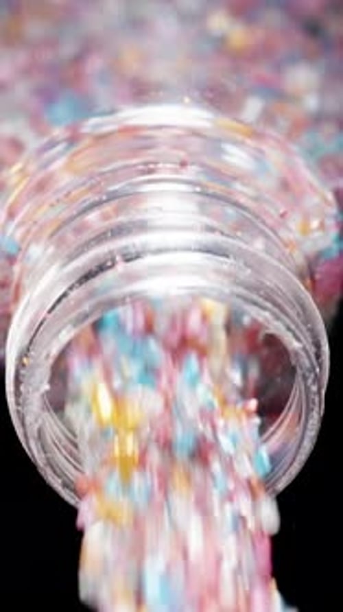Vertical video. The Camera Captures a Close-Up and Follows the Multicolored Sugar Pouring Out.