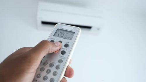 Gros plan d'un homme tenant une télécommande de climatisation