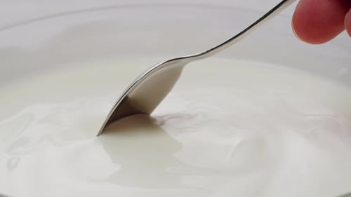 White Creamy Sauce Texture Closeup Dip a Spoon Into White Yogurt Macro Dairy Products Concept
