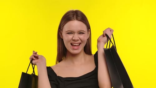 Excited Woman Holding Shopping Bags in Studio