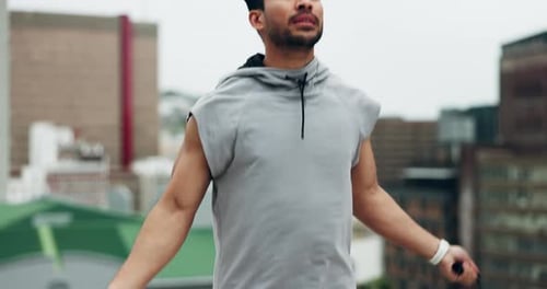 Asian man, fitness and skipping rope on rooftop in city for workout, cardio exercise