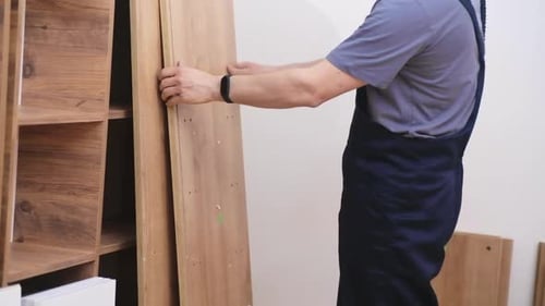 Man Assembling Wooden Cabinet in Home