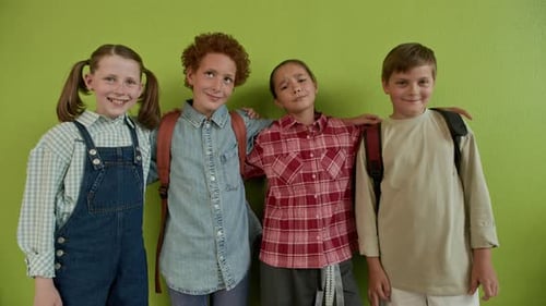 Classmates Looking at Camera with Smiles against Pistachio Green Wall
