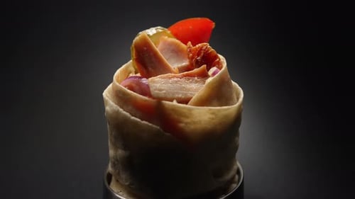 Gros plan du pain pita avec des morceaux de tomates, d'oignons et de poulet grillé