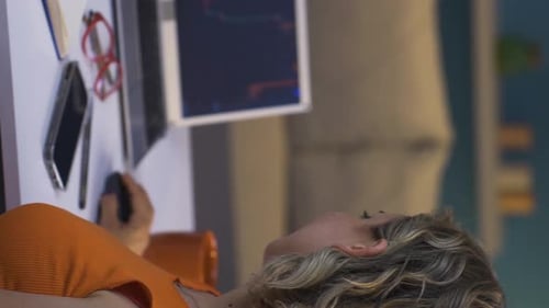 Vertical video of Investor looking at the stock market chart. She claps when she wins.