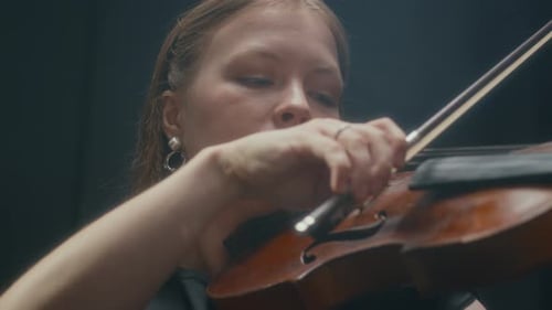 Woman Plays Violin in Dark Studio, Close Up