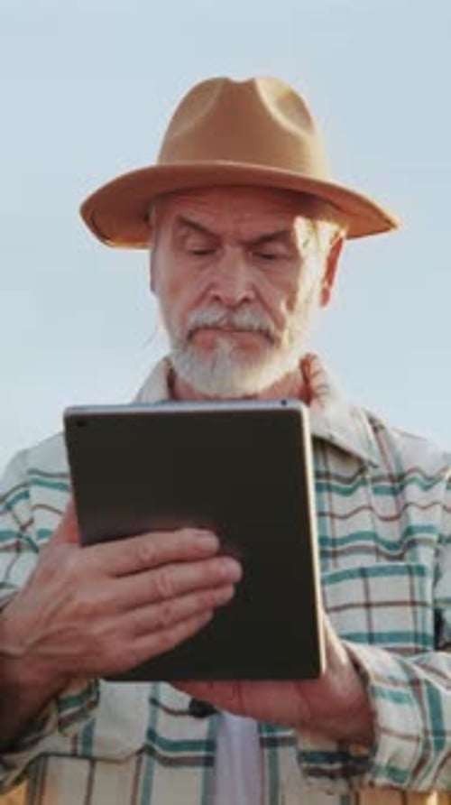 Senior Farmer Using Tablet in Rural Field