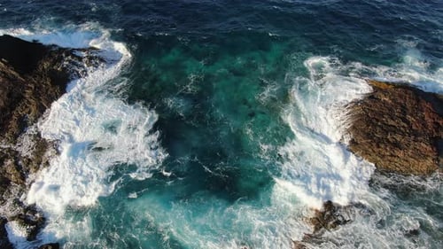 Aerial View of Waves Crashing on Rocky Coast