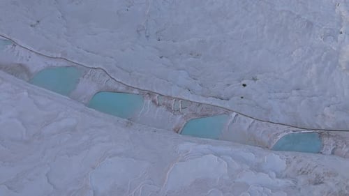 Aerial view of travertines at sunrise with hot air balloons, Turkey.