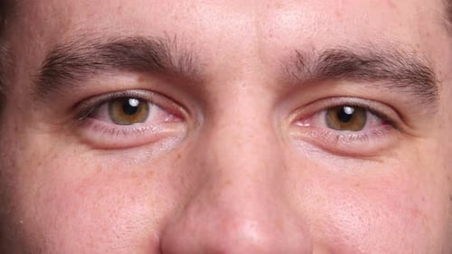 Extreme macro portrait of a confident young man smiling with expressive eyes