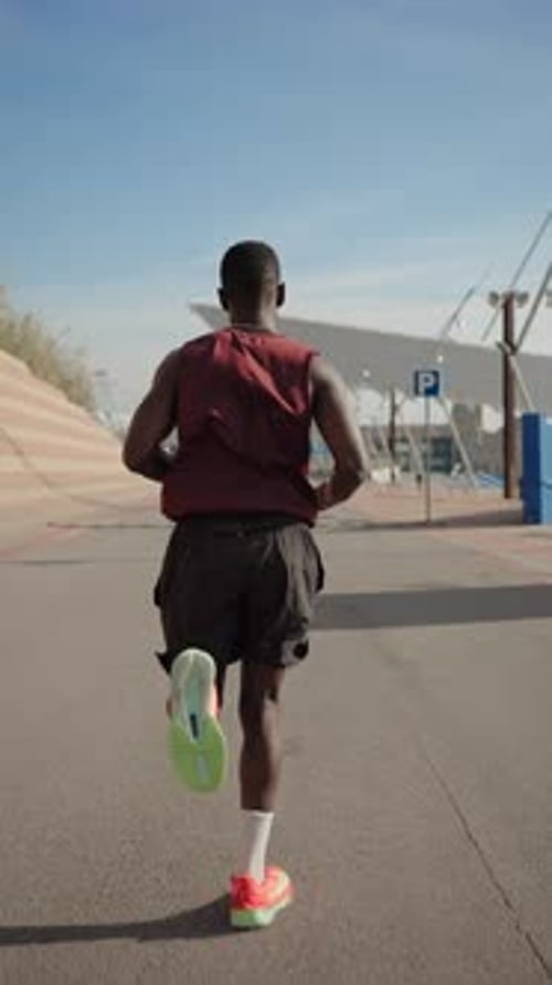 Young African Man Running on a Road Doing Sport and Training for Marathon Race