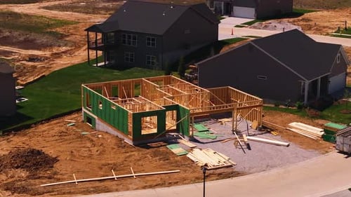 Aerial View of a Wooden House Being Built in a Suburban Neighborhood Showing Different Stages of
