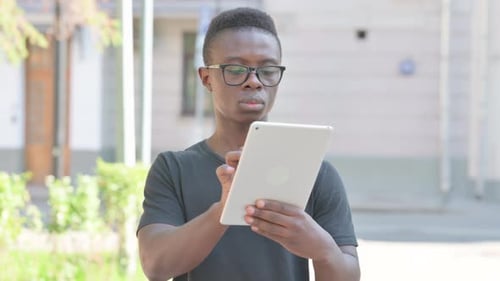 Young African Man using Tablet Outdoor