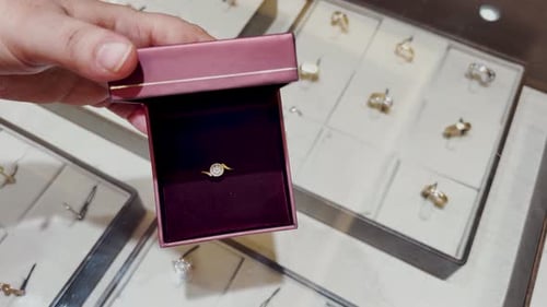 Compra de luxo abrindo uma caixa de anel de noivado de diamante na loja