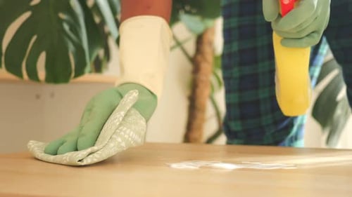 Person Cleaning Wooden Table at Home