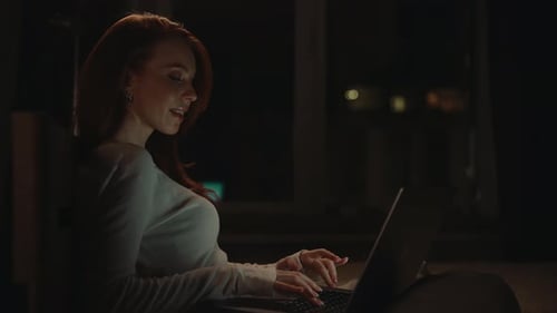 Woman Works on Laptop at Night at Home