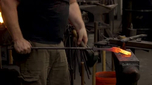 Blacksmith Shaping Hot Metal on Anvil with Hammer
