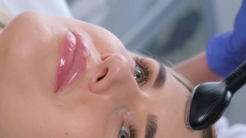 Adult Woman Receiving Facial Treatment in Clinic