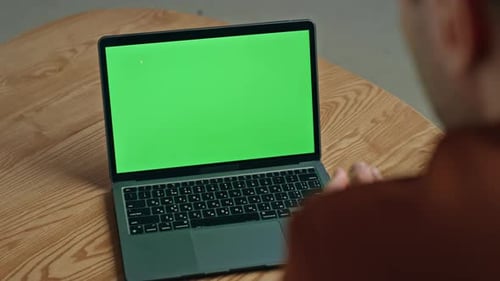Laptop with Green Screen on Wooden Table