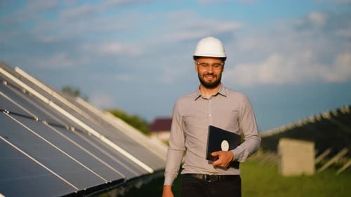 Engineer with Laptop Inspecting Solar Panels