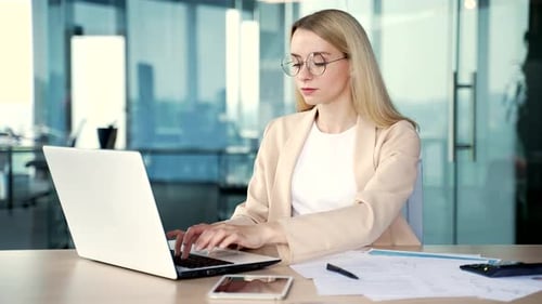 Woman Typing on Laptop at Bright Office Desk