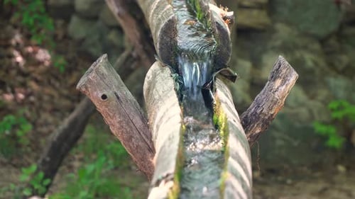 Clear fresh water flowing through open wooden pipes in Korean folk village Yongin City, Korea