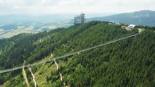 Hängebrücke über das grüne Tal zwischen Bergen