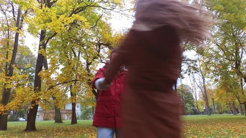 Happy young couple dancing and laughing together in autumn park romance