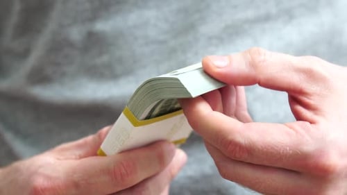 Männliche Hände zählen einen Stapel von Hundert-Dollar-US-Banknoten. Konzept des Geldaustauschs