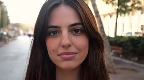 Closeup Portrait of a Young Spanish Woman Looking Seriously at Camera in a City