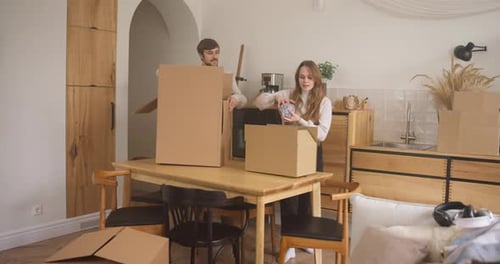 Couple Packing Cardboard Boxes in Bright Home