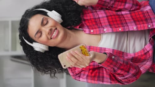 Happy Young Woman Listening to Music and Dancing