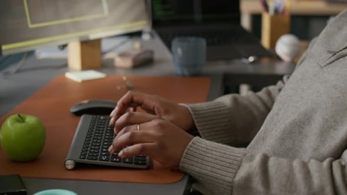 Young African American Female Programmer Coding in Modern Office