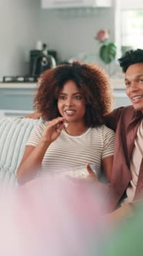 Smiling Couple Relaxing on Sofa with Popcorn