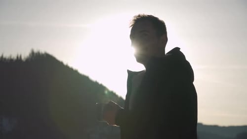 Man Drinking Hot Beverage Outdoors on Mountain