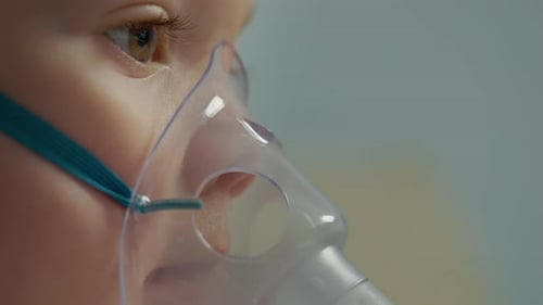 Child Wearing Nebulizer Mask for Respiratory Treatment Close Up