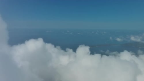 Flying Through White Clouds Over Sea