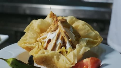 The chef pours yogurt on the food in slow motion. Cooking in restaurant, Chef serves cooked chicken