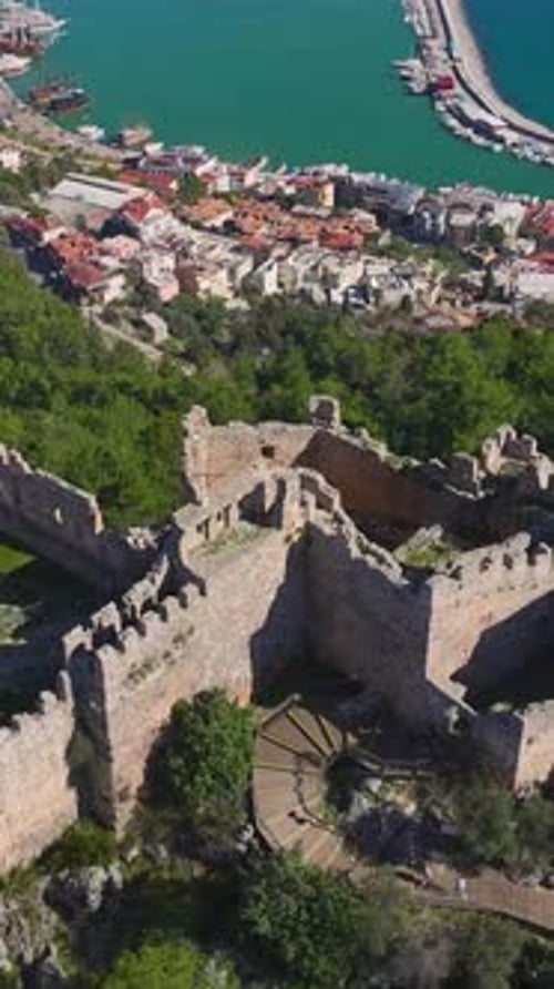 Vertical Video Aerial View of a Historic Fortress on a Hill in Alanya With Stunning City and Sea