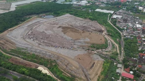 Extensive top down view showing a massive open air landfill filled with garbage, highlighting the