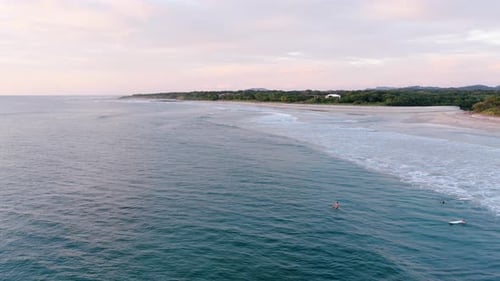 People Surfing in the Ocean During a Beautiful Sunset