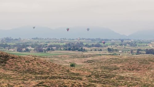 Hot Air Balloons Over Rolling Rural Hills