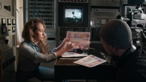 Periodista y camarógrafo discuten el plan de transmisión en un tráiler de producción televisiva