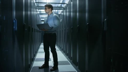 Im Rechenzentrum steht der IT-Ingenieur vor dem arbeitenden Server-Rack und führt routinemäßige Wartungsprüfungen und -reparaturen durch
