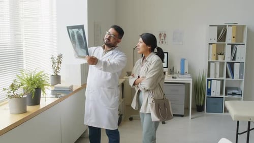 Doctor Showing X-Ray to Patient in Office