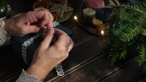 Hands Tying Ribbon on Christmas Gift