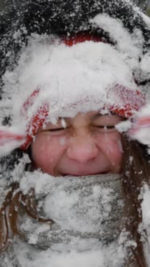 Happy Girl Covered in Snow in Winter Time