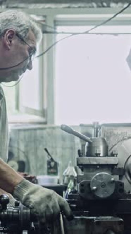 Skilled machinist using lathe in classic workshop setting