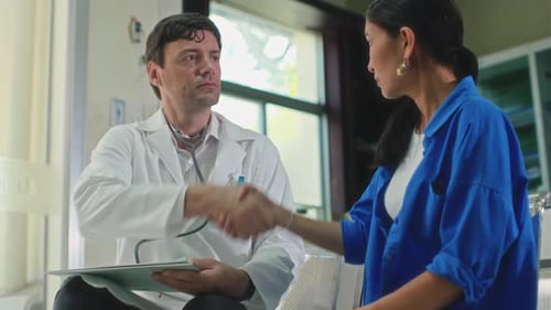 Therapist Shaking Hands of Female Patient when Meeting at Clinic